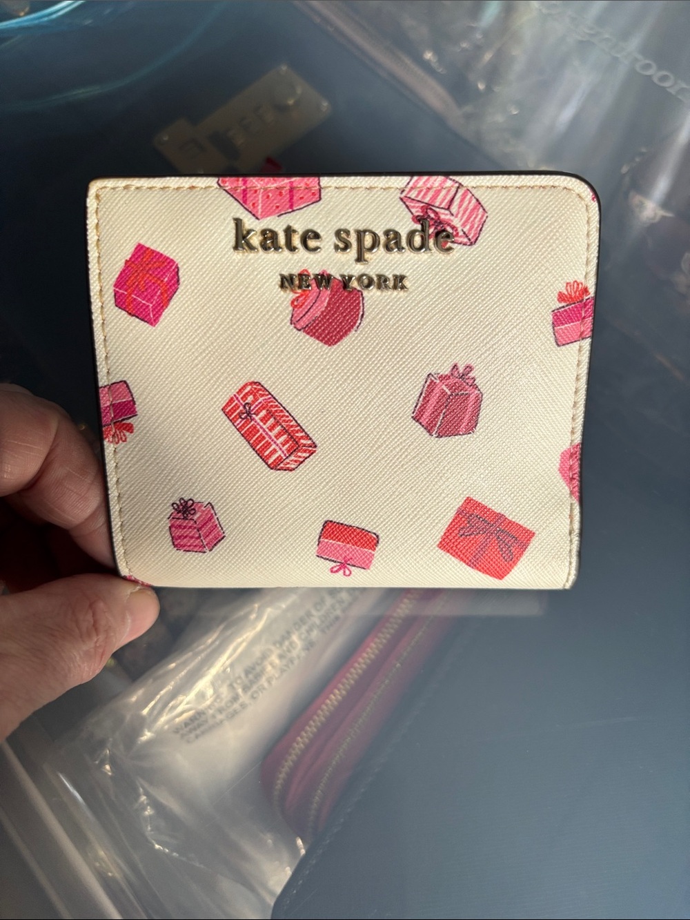 kate spade white wallet with pink and red present gift boxes